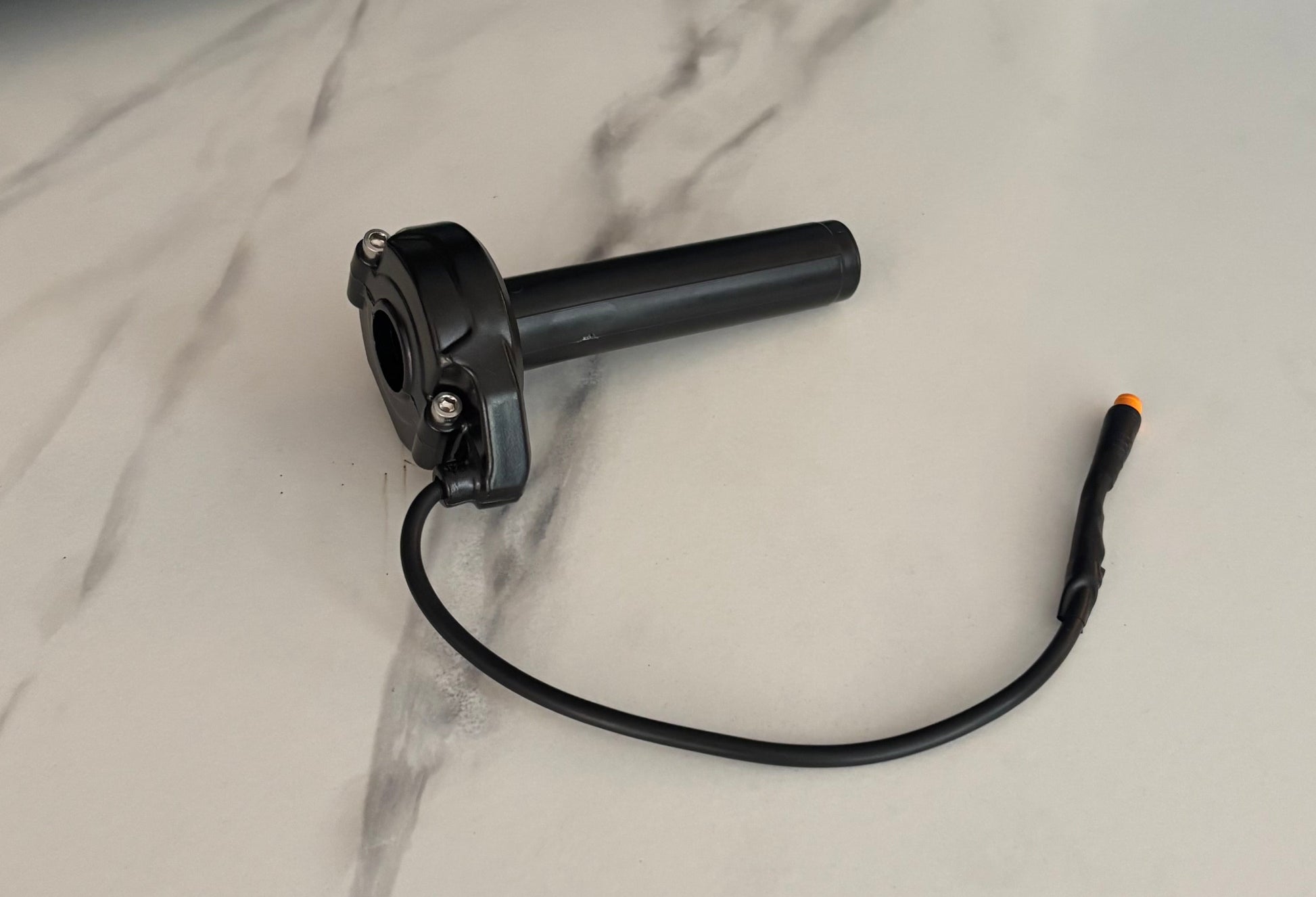 Black cylindrical device with a cable on a marble surface